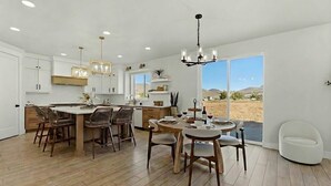 A spacious kitchen with a central island, wooden chairs, and a dining table set for six. - Modern 6br Deer Valley Retreat | Ski, Golf & Fish (Heber City)
