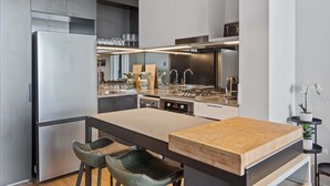A modern kitchen with a central island, stainless steel appliances, and a minimalist design. - Bright 2-Bed Apartment in Bowen Hills (Bowen Hills)