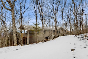 A cabin with a wooden deck and a metal roof, surrounded by trees and snow. - Adventure Awaits! Beech Mountain Home Near Skiing, Hiking & Trails (Beech Mountain)