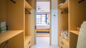 A narrow hallway leading to a bedroom with a bed, wooden shelving, and a ceiling fan. -  1 bdrm  apartment  roof top pool, gym, mountain views, 24 hr security  Barbican (Kingston)