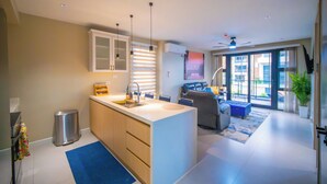 A modern kitchen with a central island, built-in cabinets, and pendant lighting. -  1 bdrm  apartment  roof top pool, gym, mountain views, 24 hr security  Barbican (Kingston)