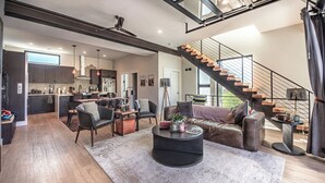 Un ambiente moderno con una scala, una zona pranzo e una cucina.