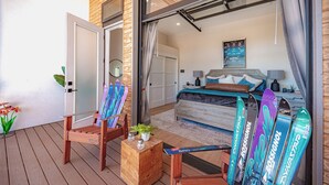 Una camera da letto con un letto, una scrivania, una sedia, pavimento in legno e una finestra con tende.