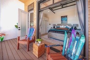Ein Schlafzimmer mit Bett, Schreibtisch und Stuhl, Holzboden und einem Fenster mit Vorhängen.