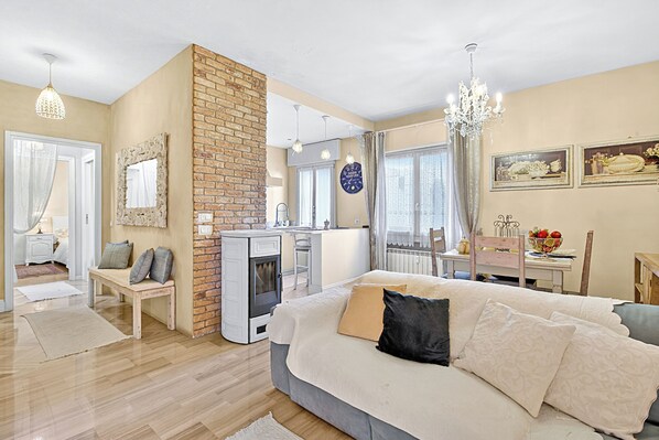 A cozy bedroom with a large bed, a fireplace, and a dining area with a table and chairs. - Chic Retreat With Park Central Salo (Salò)