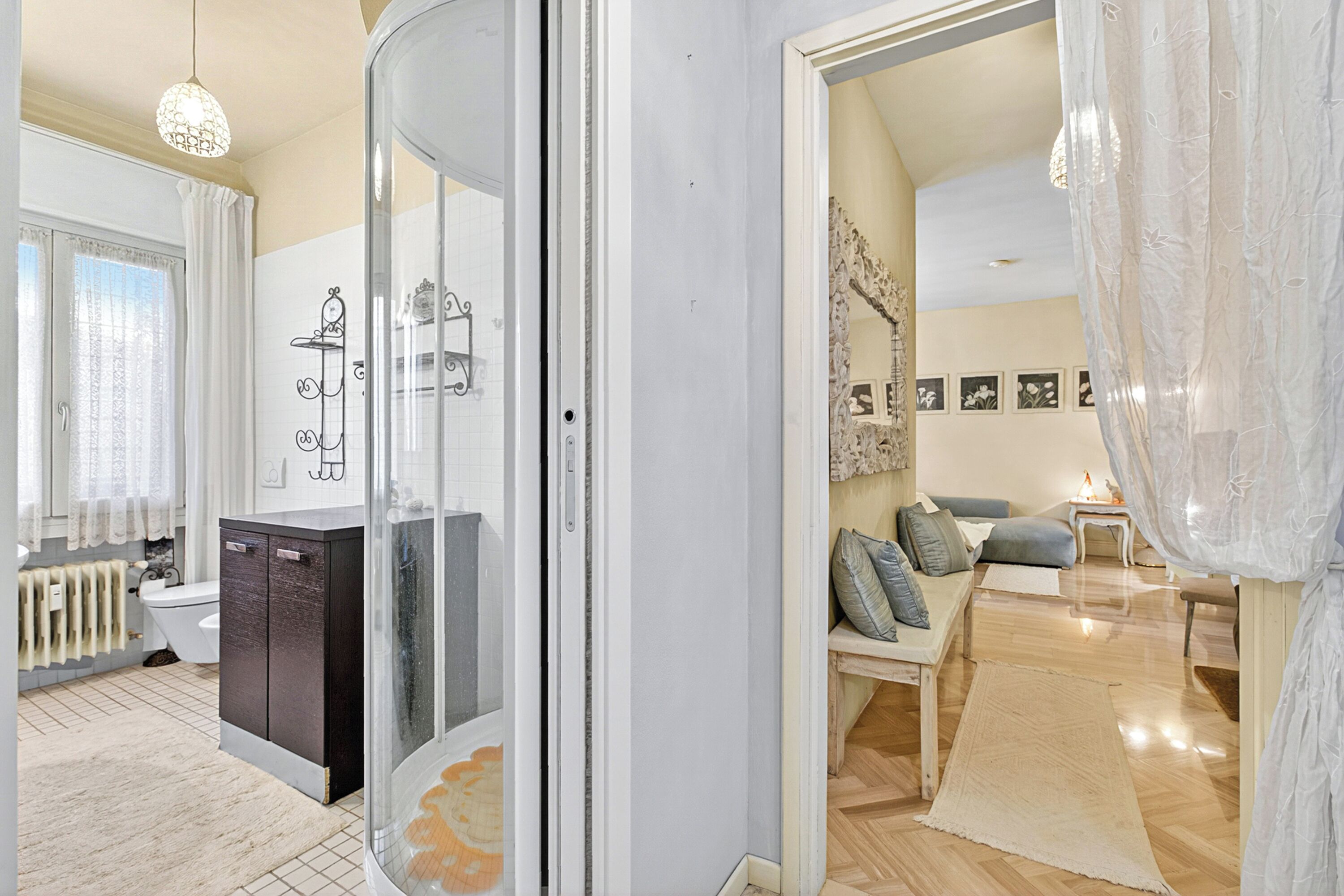 Un baño moderno con cabina de ducha de vidrio, un mueble de madera oscura y un lavabo blanco.