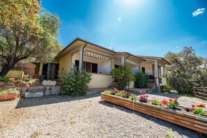 A two-story house with a covered porch, surrounded by gravel and potted plants. - Casa Luppoli - Casa Luppoli - Bilocale 4/5 posti (Portoferraio)