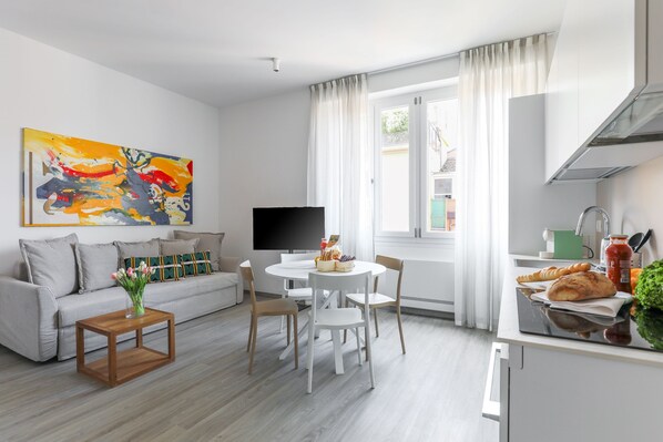 Ein modernes Wohnzimmer mit Sofa, Couchtisch und Essbereich.
