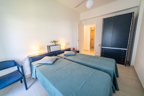 A bedroom with two beds, a desk, a chair, a wardrobe, and a ceiling fan. - La Conchiglia - Four-room apartment (Marina di Campo)