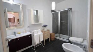 Et moderne badeværelse med bruser, toilet og håndvask.
