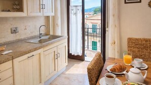 Uma cozinha com área de refeições, vista para o exterior e itens de café da manhã sobre a mesa.