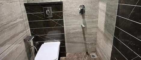 A modern bathroom with a toilet, a shower, and a sink.