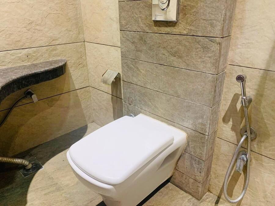 A bathroom with a white toilet, a shower, and a towel rack.