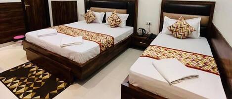 Chambre triple luxueuse | Lit avec matelas Ă plateau-coussin, bureau, fer et planche Ă repasser