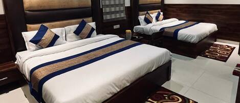 A hotel room with two beds, each with a headboard, a nightstand, and a bedside table.