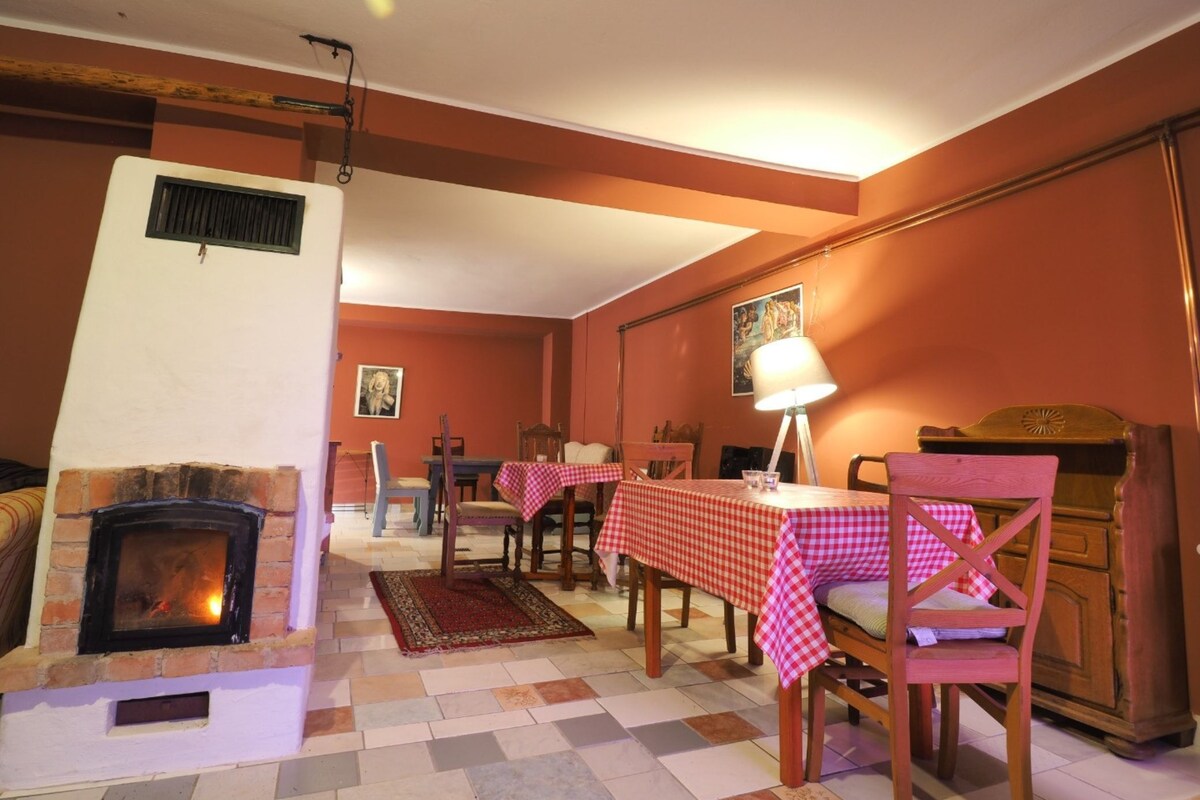 A cozy room with a fireplace, wooden furniture, and a checkered tablecloth.