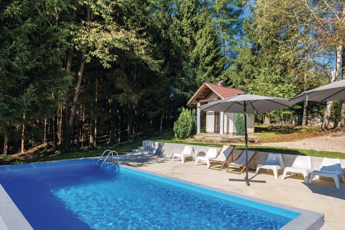 A swimming pool with lounge chairs and a small building with a red roof.