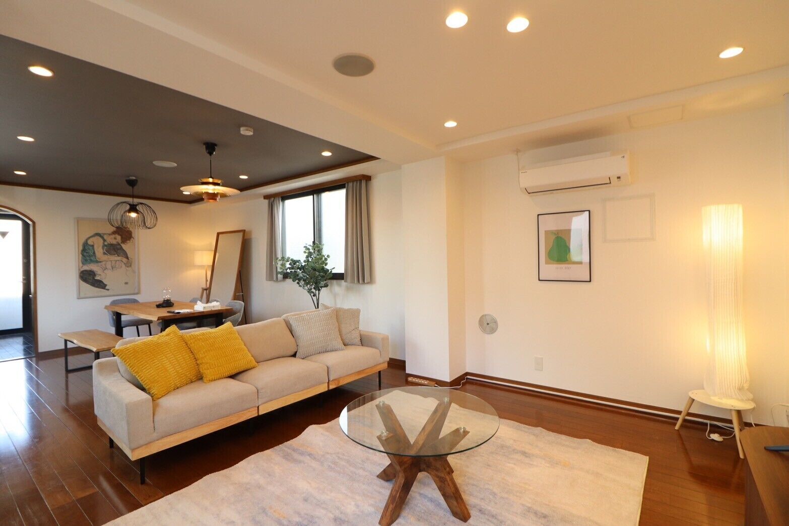 A modern living room with a sofa, coffee table, and dining area.