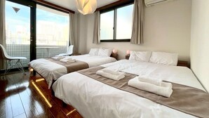 A hotel room with two beds, a view of the city, and a balcony. - Yokohama Mega Stay (Yokohama)