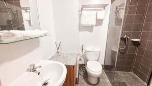 A bathroom with a sink, toilet, and shower.