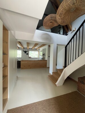 A spacious interior with a staircase, wooden beams, and a kitchen area. - MAURICETTE Chalet—Completely renovated in La Plagne, ideal for families (6 adults/4 children) (La Plagne Tarentaise)