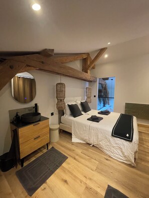 A bedroom with a wooden ceiling, a round mirror, a bed with white bedding, and a bedside table with a black basin. - MAURICETTE Chalet—Completely renovated in La Plagne, ideal for families (6 adults/4 children) (La Plagne Tarentaise)