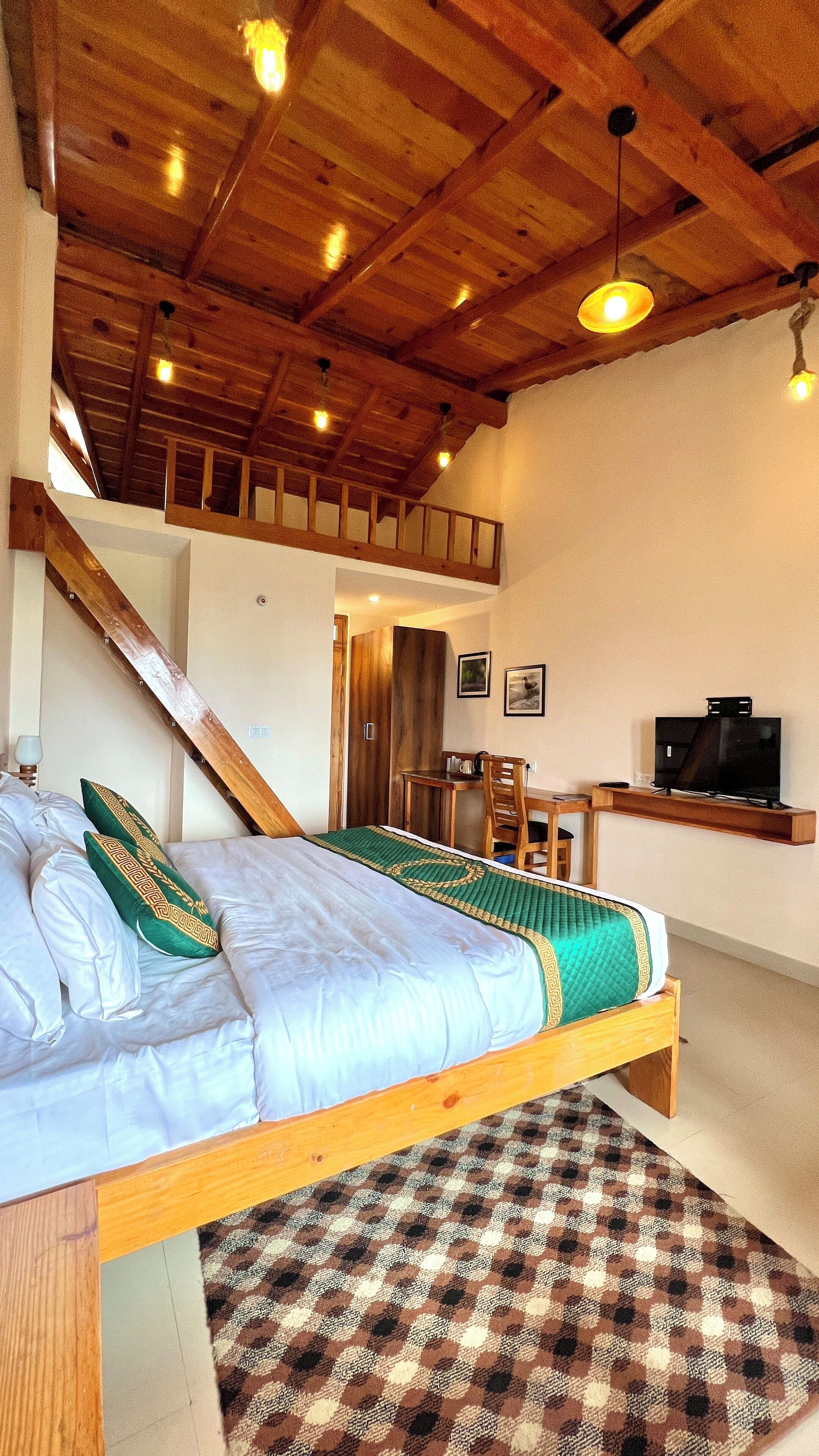 Quarto com cama de madeira, escrivaninha, televisão e escada.