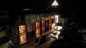 Un hotel con varios pisos, balcones e interiores iluminados.