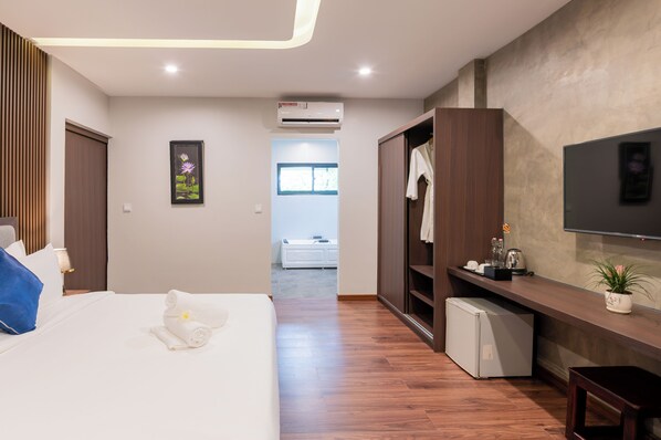 A modern hotel room with a bed, a TV, a wardrobe, a small fridge, and a bathroom visible in the background. - The Sears Residence (Siem Reap)