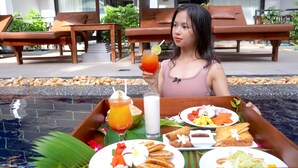 A dining area with a tray of food and drinks, including a tropical drink, a glass of milk, and various dishes. - The Sears Residence (Siem Reap)