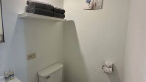 Ein kleines, sauberes Badezimmer mit Toilette, Waschbecken und Mülleimer.