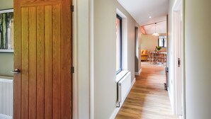 A hallway with a wooden door, a radiator, and a dining area with a table and chairs. - Lakeside Lodge - UK50627 (Welshpool)