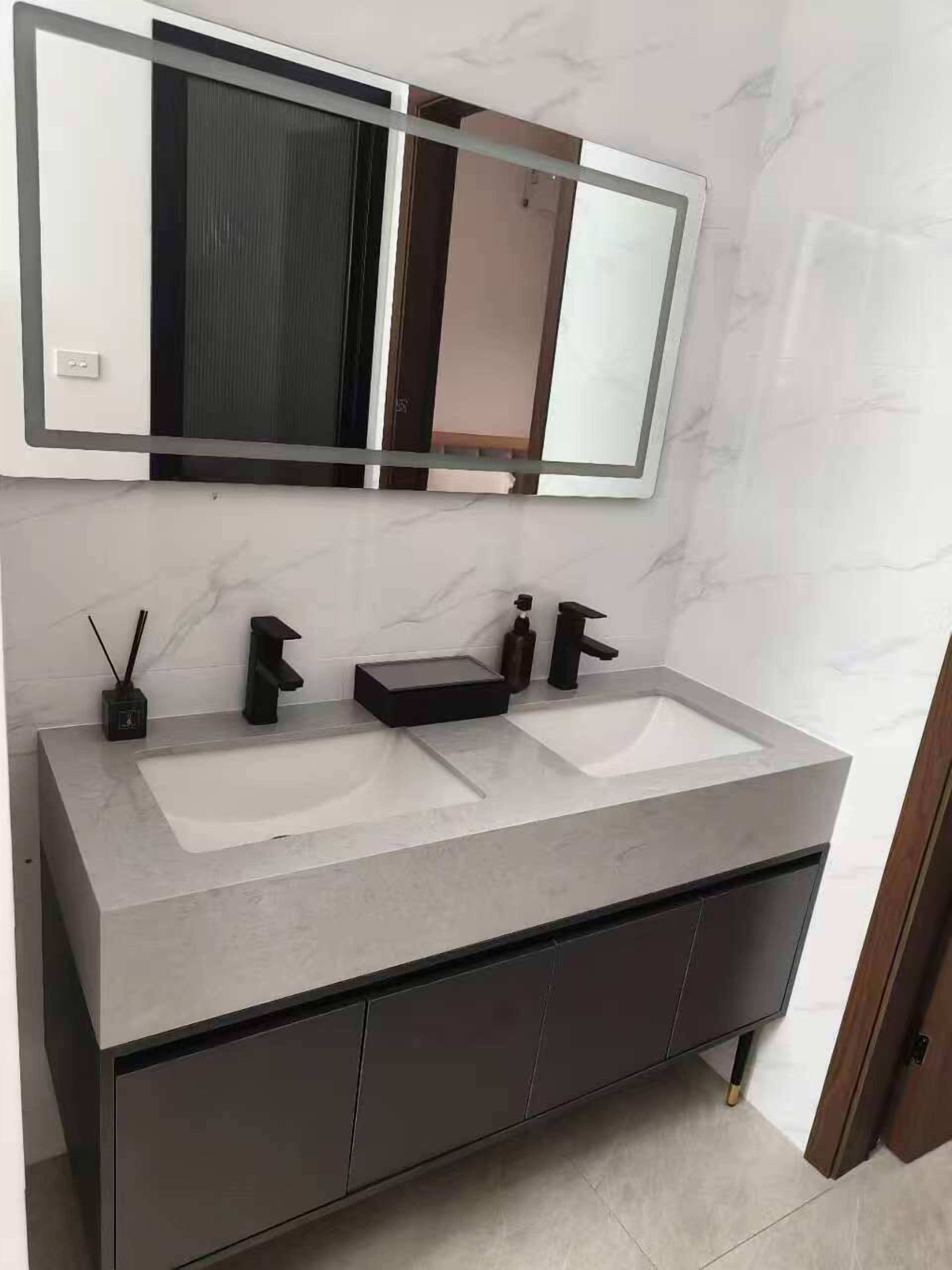 A bathroom with a double sink vanity, a large mirror, and a cabinet below.