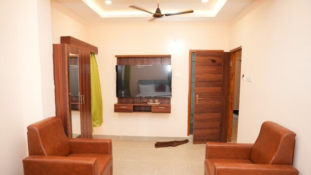 Una habitación con dos sillones de cuero marrón, un armario de madera, un espejo y un ventilador de techo.