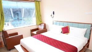 Una habitación de hotel con cama, escritorio y silla.