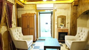 A room with two white armchairs, a checkered floor, a wooden wardrobe, a small table, and a mirror. - Hurşitbey Konağı (Gaziantep)