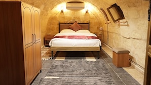 A bedroom with a bed, wooden wardrobe, and a small stool. - Hurşitbey Konağı (Gaziantep)