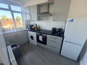 Eine moderne Küche mit Waschmaschine, Backofen und Kühlschrank.
