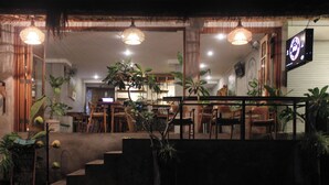 A restaurant with a staircase leading to the seating area, surrounded by potted plants. - Tusantha Ubud A Trishula Collection (Ubud)