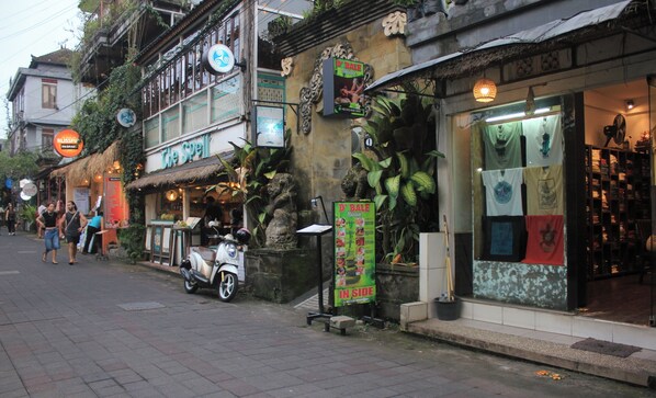 Une rue commerçante, où l’on trouve des boutiques, notamment un salon de massage et un magasin de vêtements.