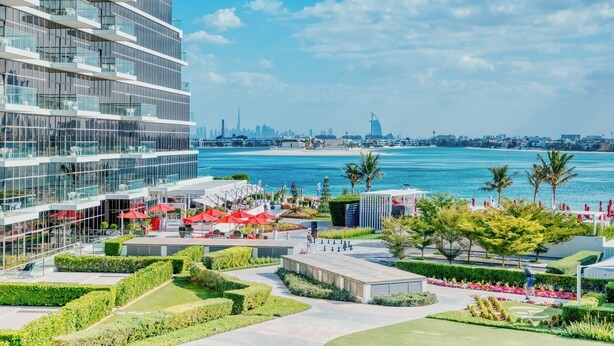 A modern hotel with a glass facade overlooking a marina and city skyline. - PVH - The8 - Opulent 3BR - Beach Access (Dubai)