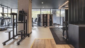 A modern gym with various exercise equipment, large windows, and a clean, minimalist design. - The Central Mount-Balcony-Gym-Parking (Manchester)