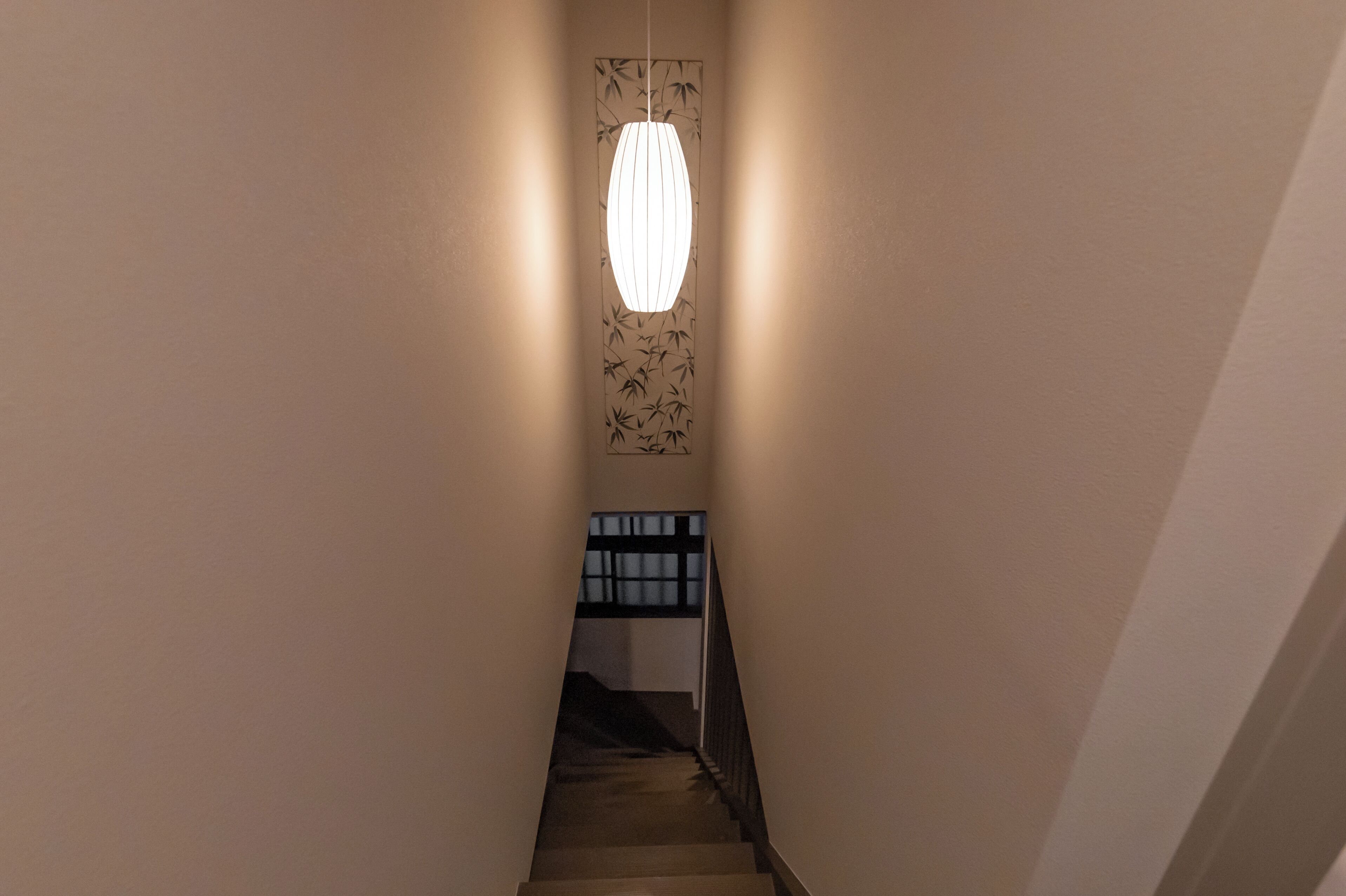 A narrow hallway with a staircase leading to a landing.
