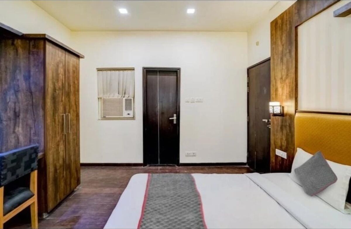 A bedroom with a bed, wardrobe, and a door.