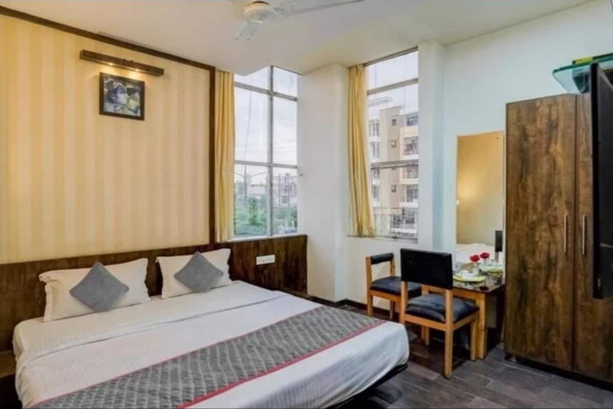 Una habitación de hotel con cama, escritorio y armario.