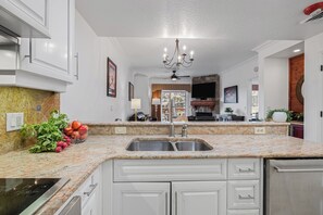 Eine moderne Küche mit Granit-Arbeitsplatten, Edelstahlgeräten und weißen Schränken.