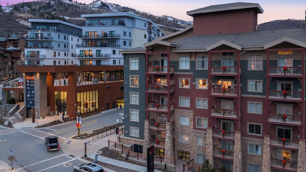 Ett hotell med flera våningar, balkonger, en central innergård och utsikt över ett bergigt landskap.
