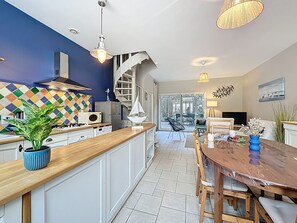 Una cucina moderna con un piano di lavoro in legno, una scala a chiocciola e un'area pranzo con tavolo e sedie in legno.