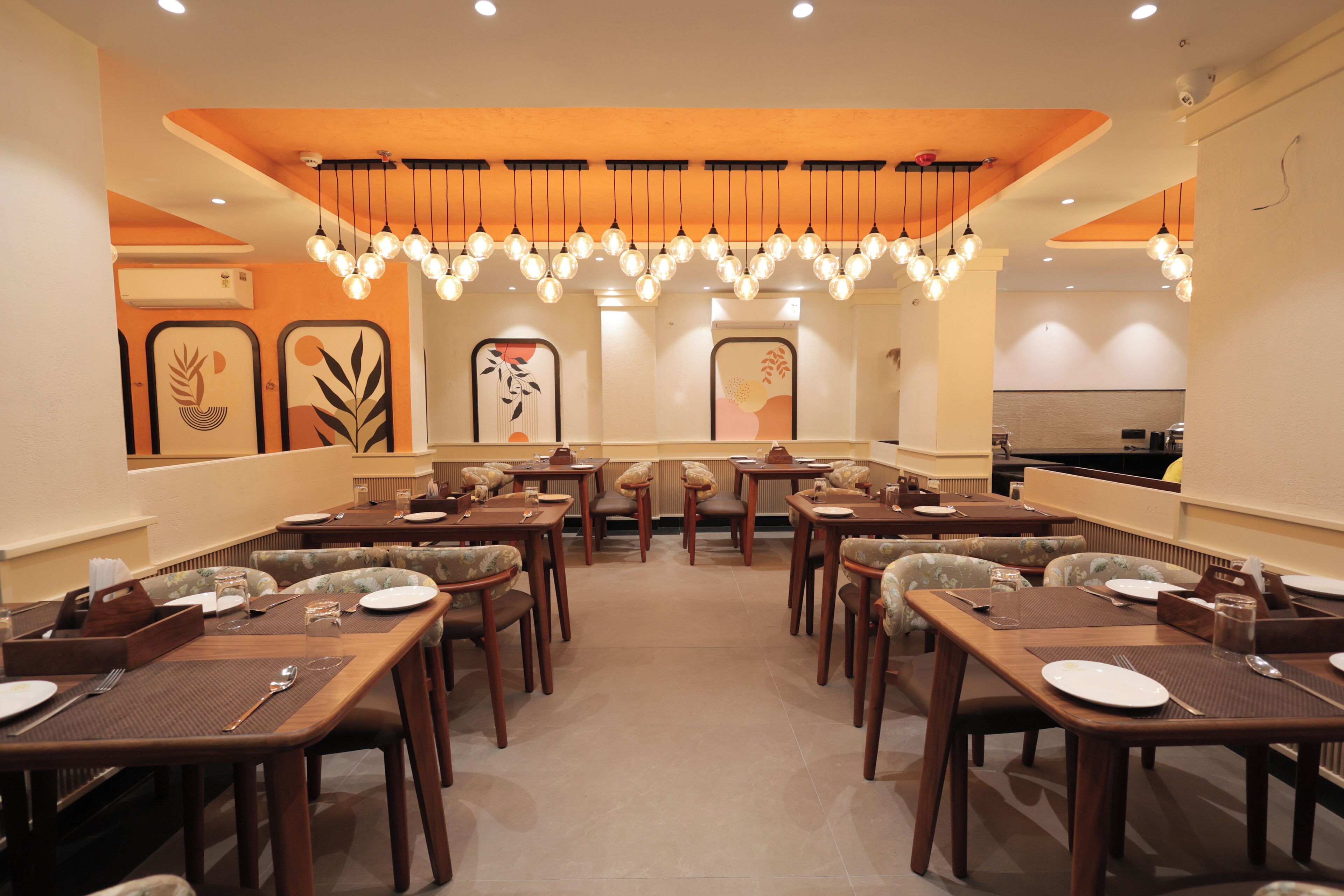 A restaurant with multiple dining tables and chairs, arranged in a spacious layout.