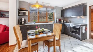 Een moderne keuken met een eettafel, stoelen, een magnetron en een oven.